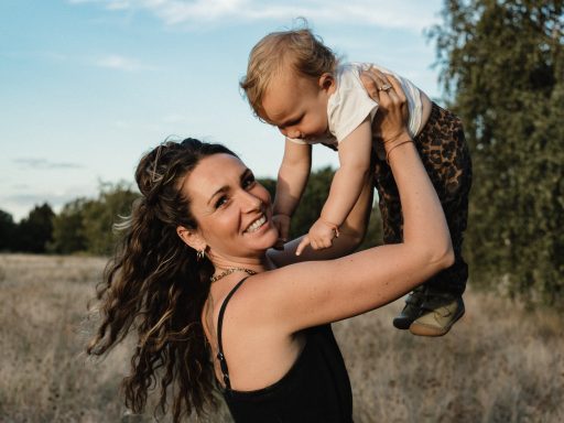Mutter hebt ihr Baby in die Luft bei einem Familienshooting mit familara Fotografie in Berlin Biesdorf