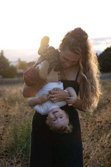 Mutter schmiegt ihr Baby liebevoll an sich bei einem Shooting mit familara Fotografie