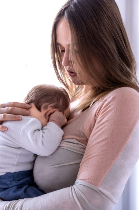 Frau mit Neugeborenem Baby auf dem Arm
