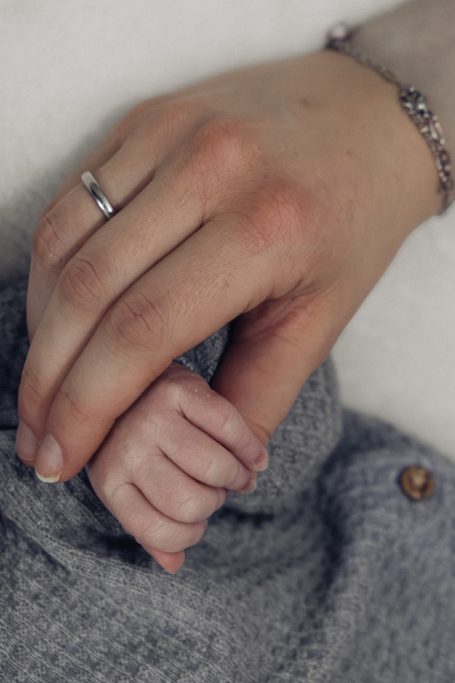 Händchen eines Babys, das von einer erwachsenen Hand gehalten wird.