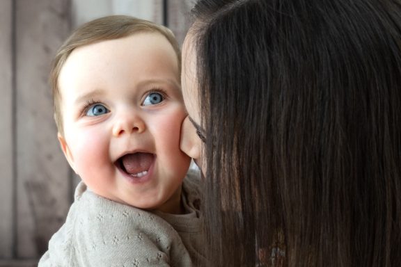 Baby und Schwester kuscheln